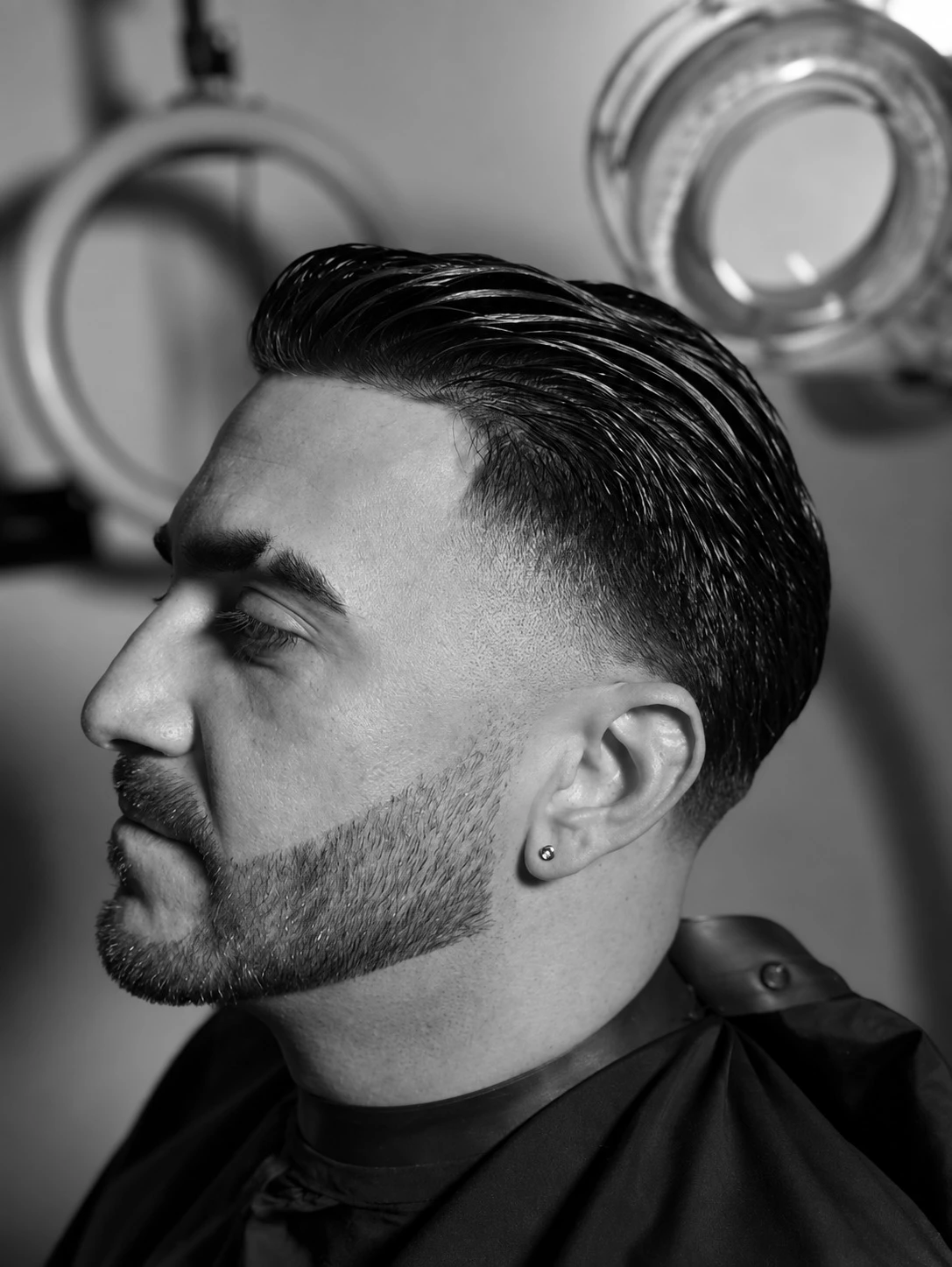 Retrato en blanco y negro de un cliente con cabello peinado y barba definida